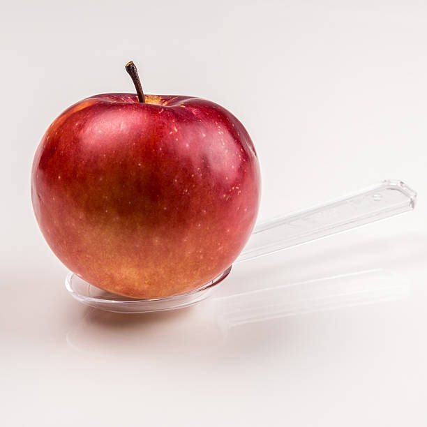 istock red apple on translucent medicine spoon on the table 527567097