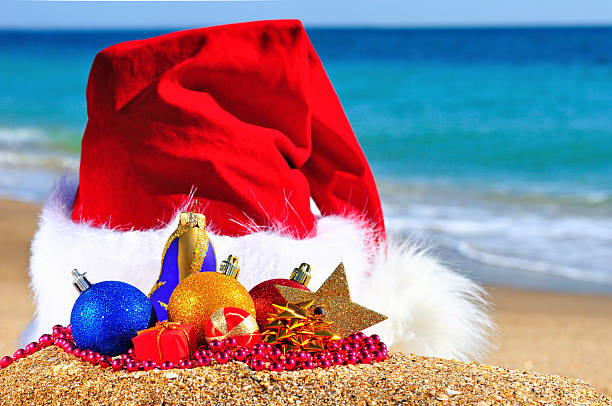 istock Christmas hat with colored baubles on the seashore 527571699