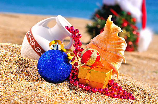 istock Christmas tree, antique vase, christmas baubles, gift box on the sand 527571703