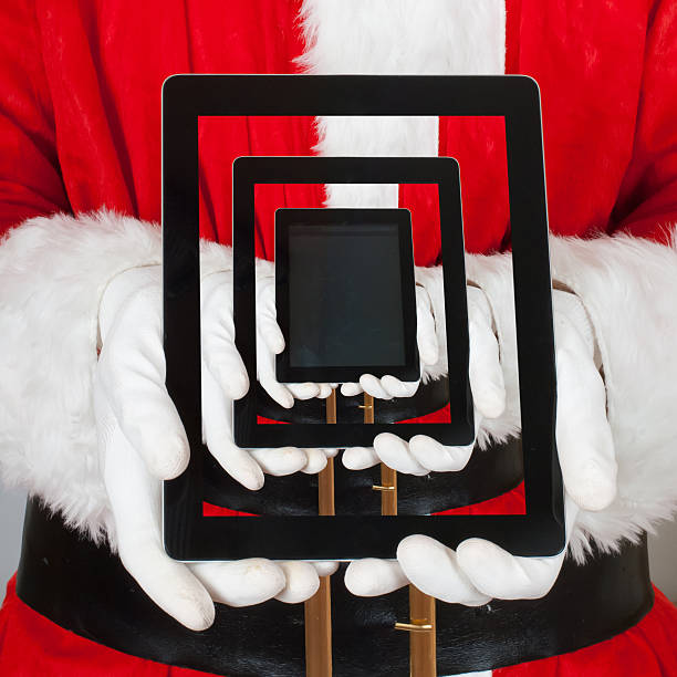 istock Santa Claus Showing a Gift in to his Digital Tablet 527579103