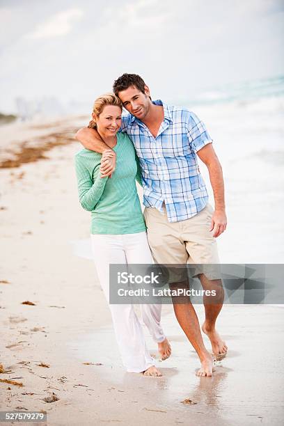 Loving Couple Walking On Beach Embracing Stock Photo - Download Image Now - 30-39 Years, Adult, Adults Only