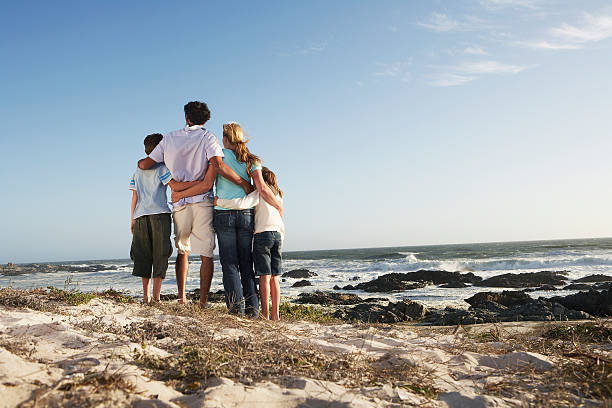 istock Family Standing Together On Seashore 527581693