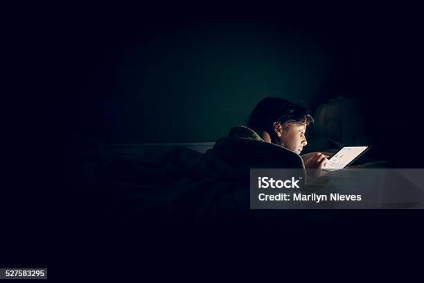 Child Reading Tablet In Bed At Night Stock Photo - Download Image Now - Child, Digital Tablet, Bed - Furniture