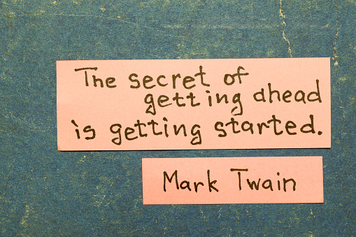 The secret of getting ahead is getting started - famous American writer Mark Twain quote interpretation with pink notes on vintage carton board