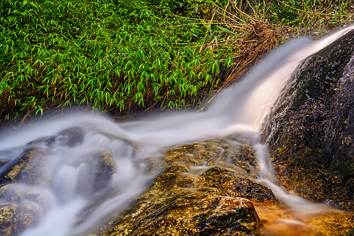 Beautiful silky waterfall flow through stones, Huay Kaew Waterfall, Chiang mai Province, Thailand.