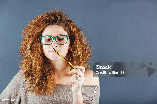 Pensive Curly Young Woman On Gray Background Stock Photo - Download Image Now - Adult, Beautiful People, Beauty