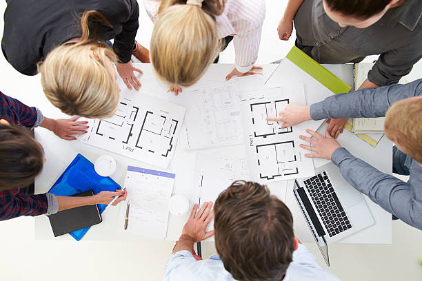 istock Overhead View Of Architects Discussing Plans In Office 527615139