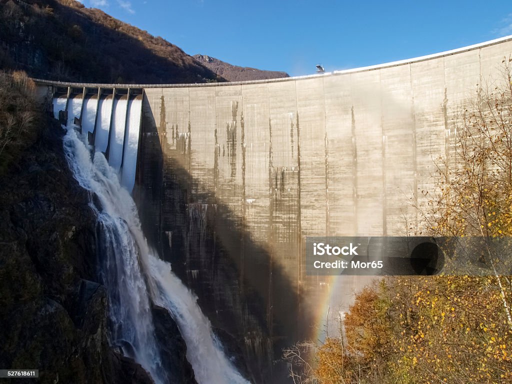 Dam of Contra Verzasca, spectacular waterfalls Dam of Contra Verzasca Ticino, Switzerland: spectacular waterfalls from the overflow of the lake Awe Stock Photo