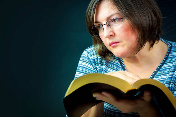 istock Adult Woman meditating while Reading the Bible 527618911