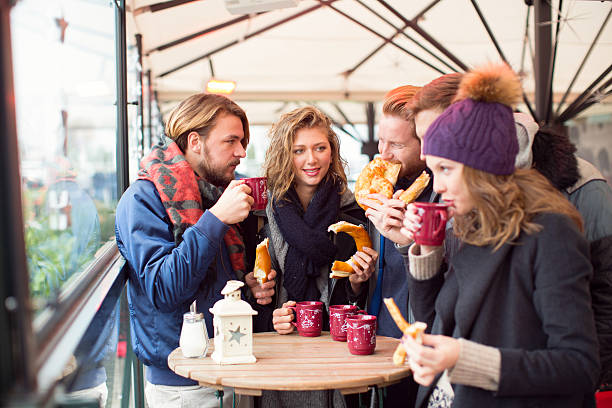 istock Friends having hot drinks outdoors in winter city. 527630839