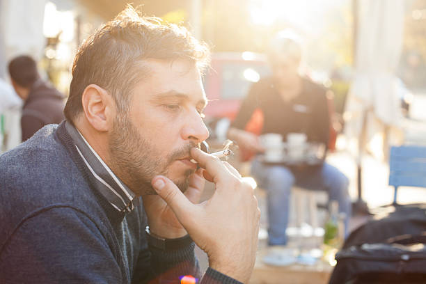 Hombre fumar en día soleado al aire libre - foto de stock