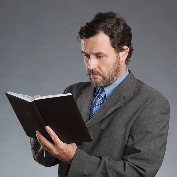 istock Businessman writing in organizer against gray background 527634543