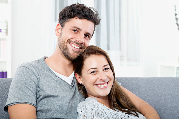 istock Happy young couple sitting at home on couch 527635441