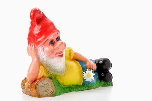 Lying garden gnome holding flower