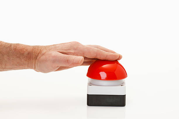 Hand pressing red game show buzzer stock photo