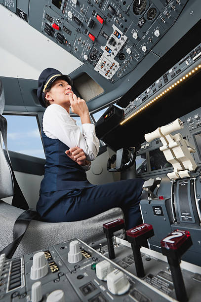 istock Female pilot thinking which button to press in airplane cockpit 527636425