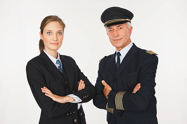 istock Senior captain and young air hostess on white background 527636653