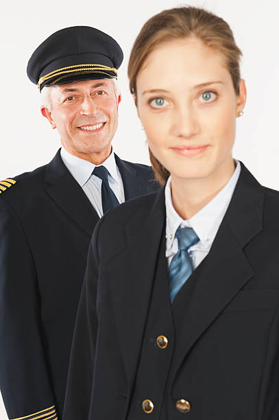 Senior captain and young air hostess on white background
