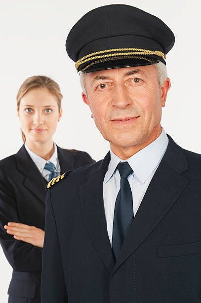 istock Senior captain and young air hostess on white background 527636701