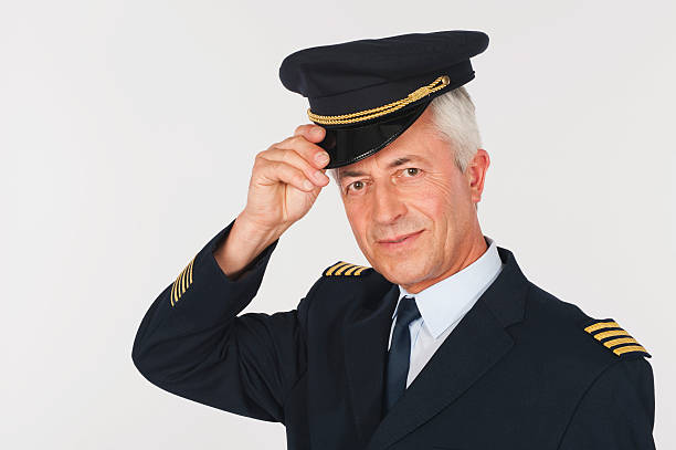 istock Close up of senior flight captain saluting on white background 527636717