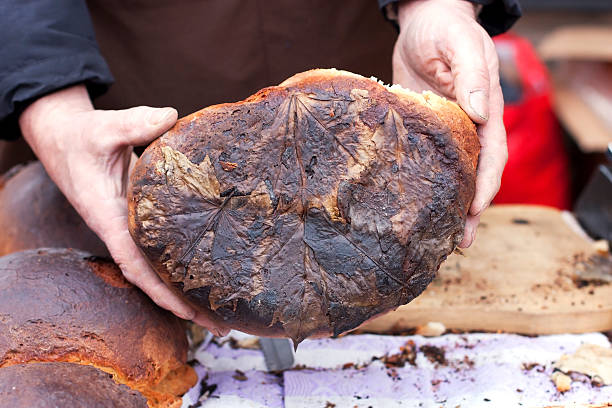 istock Baker man holding rustic organic loaf of bread in hands 527637047