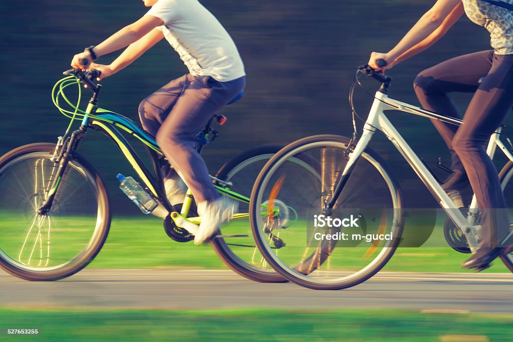 Cyclists in Blurred Motion Two (male/female) cyclists in blurred motion driving on a forest road. Photo has intentional off-focus and slight blur to make a impression of speed and action. Bicycle Lane Stock Photo