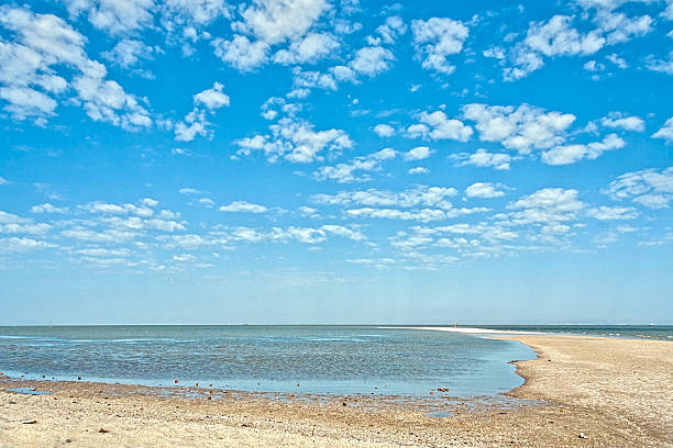 istock Deserted beach on a background of blue sky with clouds 527662724