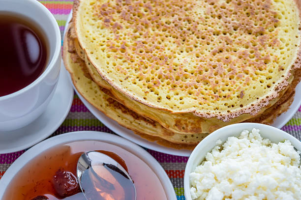 istock Pancakes with strawberry jam, cheese and cup of tea. 527665442