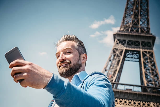 istock beautiful bearded tourist taking selfie in front of Eiffel tower 527667326