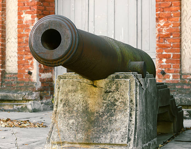 Old Medieval iron cannon on concrete stand. Photo is taken with dslr camera in some old town in Europe. Cannon is located in area called 
