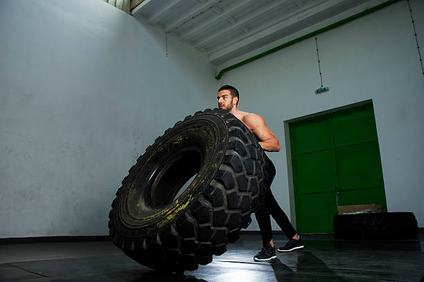 istock Bodybuilder flipping tire at the gym 527671250