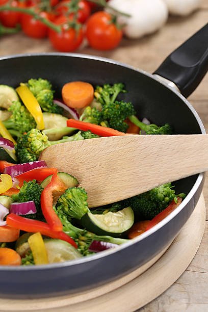 istock Preparing veggie food vegetables in cooking pan with spatula 527673415