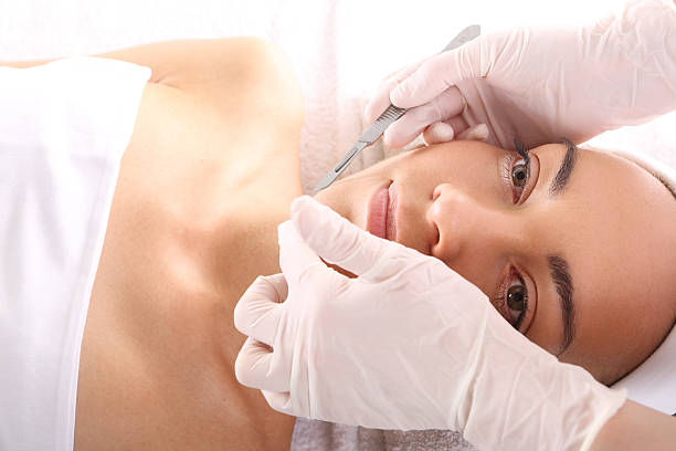 Exfoliating the skin with a scalpel Caucasian woman during surgery using a scalpel scalpel photos stock pictures, royalty-free photos & images