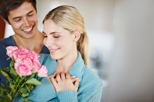 Shot of an affectionate young man giving his beautiful young wife a bouquet of pink roses