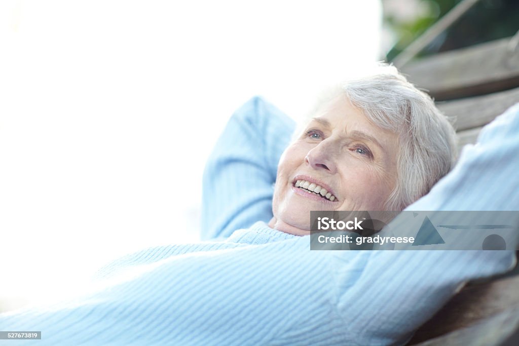 Live your life and forget your age Cropped shot of a senior woman lying on a hammock and enjoying the outdoors Hands Behind Head Stock Photo