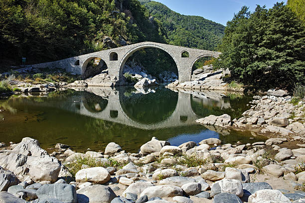 istock Reflection of Devil's Bridge and Rhodopes mountain in Arda river 527674028