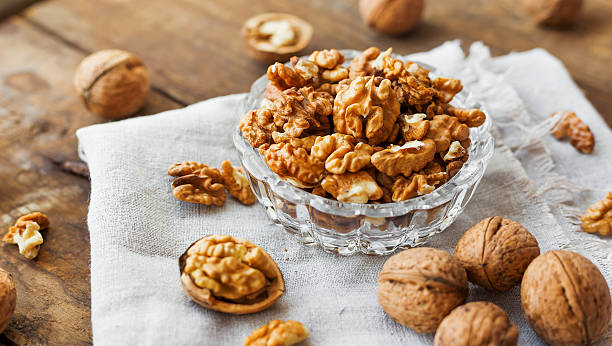 istock Glass bowl with walnuts on rustic homespun napkin. Healthy snack. 527676044