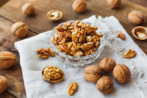 istock Glass bowl with walnuts on rustic homespun napkin. Healthy snack. 527676136