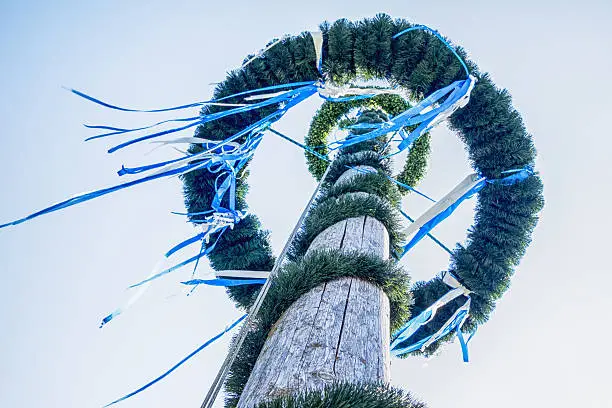 typical bavarian maypole in front of blue sky