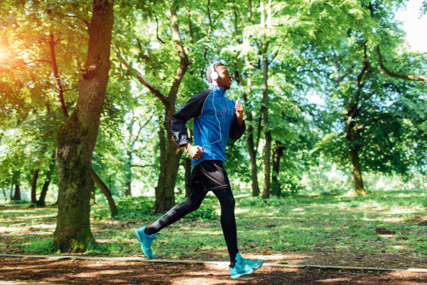 jeune homme faire du jogging en plein air. - black forest audio photos et images de collection