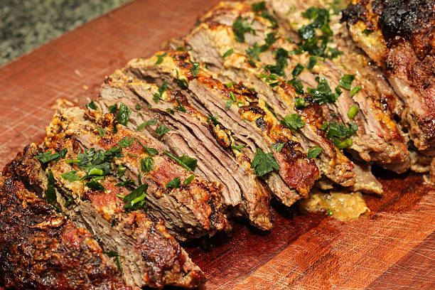 istock Roast beef with mustard sauce and herbs chopped on board. 527679398