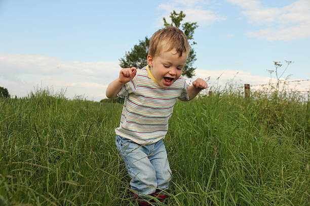 istock Little boy playing in field of grass 527679529