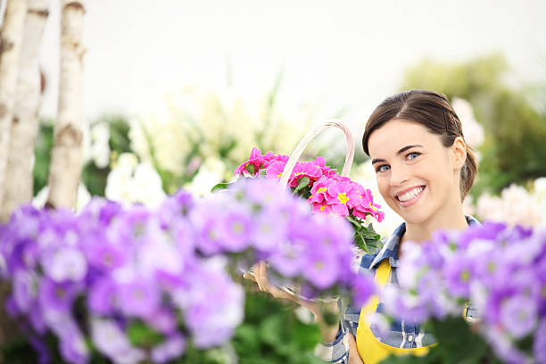 istock springtime, woman smiling with white wicker basket flowers 527680930