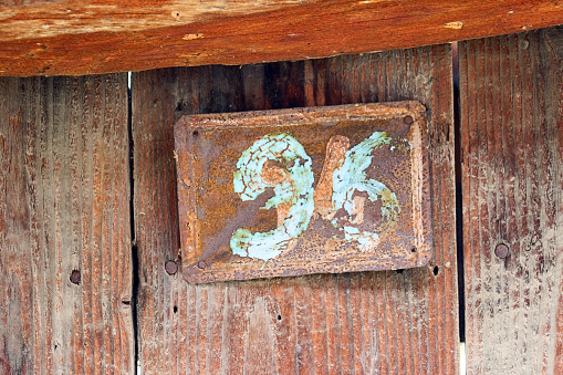 picture of a rusty metal plate with door number 96