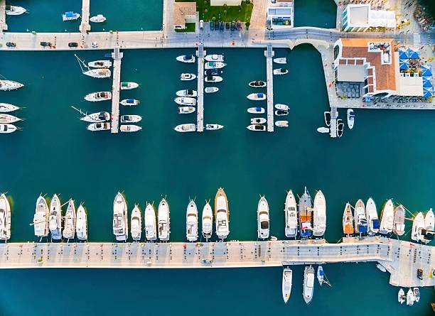 Aerial view of Limassol Marina, Cyprus Aerial view of the beautiful Marina in Limassol city in Cyprus, the boats lined up, piers, and commercial area from above. A very modern, high end and newly developed space where yachts are moored and it's perfect for a waterfront promenade. limassol marina stock pictures, royalty-free photos & images