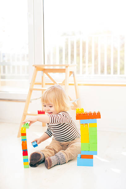 istock Cute child playing with colorful plastic blocks 527687616