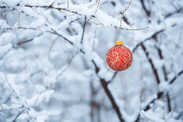 Christmas Ornament in the Snow A red Christmas ornament outdoors in the snow. filligree stock pictures, royalty-free photos & images