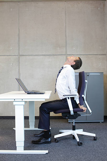 istock exercises in office. business man arm-neck stretching 527690337