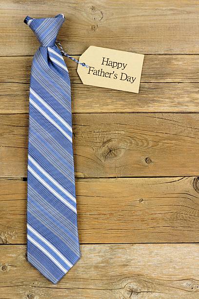 istock Happy Fathers Day gift tag with blue tie on wood 527690684