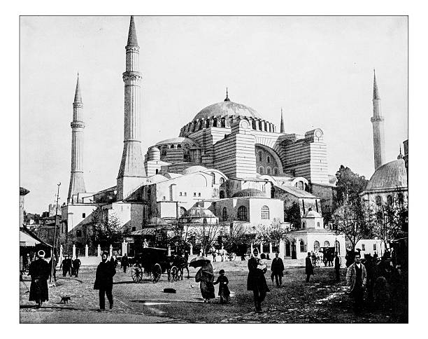 Antique photograph of Hagia Sophia (Istanbul, Turkey)-19th century Antique photograph of view of Hagia Sophia (Istanbul, Turkey) in a 19th century photograph taken from a square busy with people and carriages. The building is a former Christian basilica (church), then used as a mosque and now a mosque-museum, built from the 6th century. In the picture three of the four minarets and the massive dome istanbul photos stock illustrations